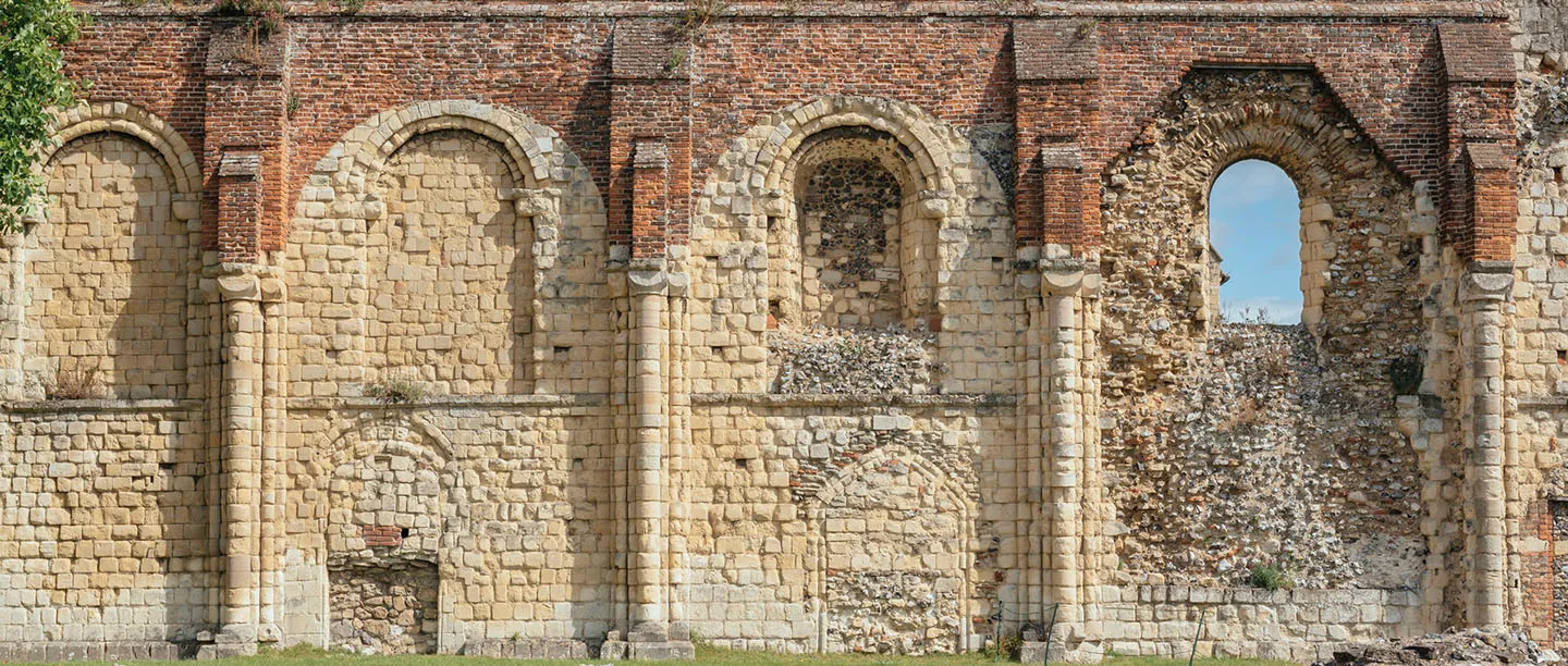 Close view of the arched stone and brick wall of the abbey church