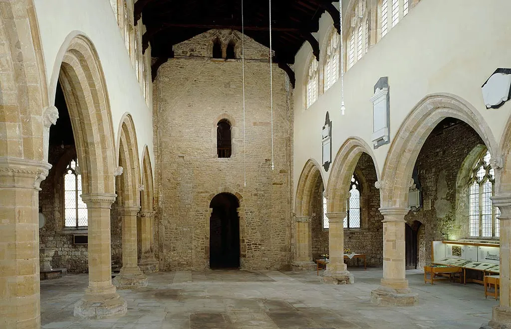 The empty stone-flagged nave of St Peter's, Barton-upon-Humber, with pointed arcades leading to the tower arch
