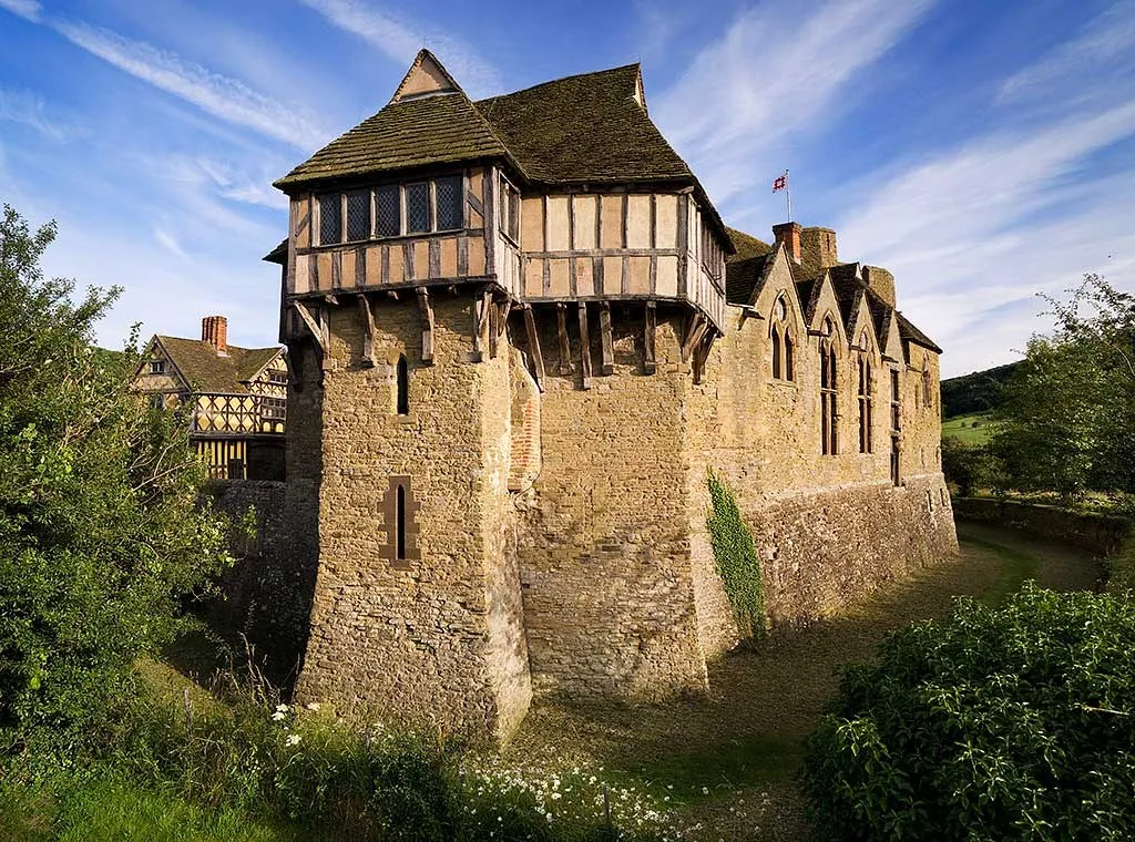 The north tower's jettied timber upper storey above the moat, with the gatehouse beyond