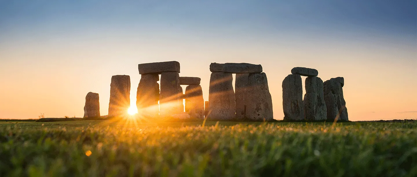 The sun low behind the stone circle