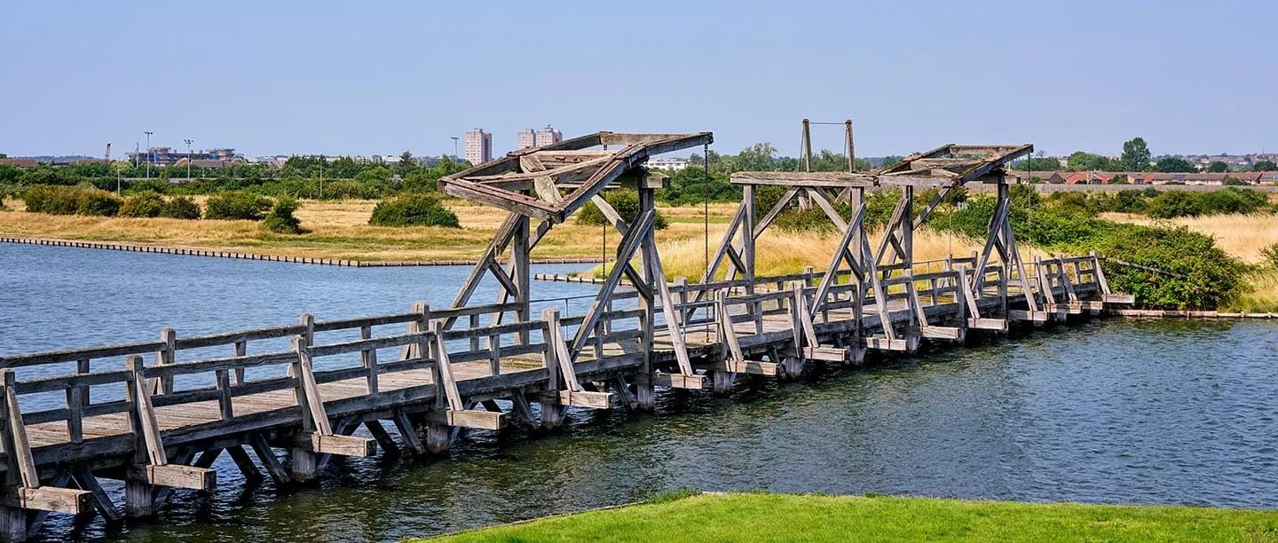 The restored timber bridge with its lifting frames crossing the moat on a summer day