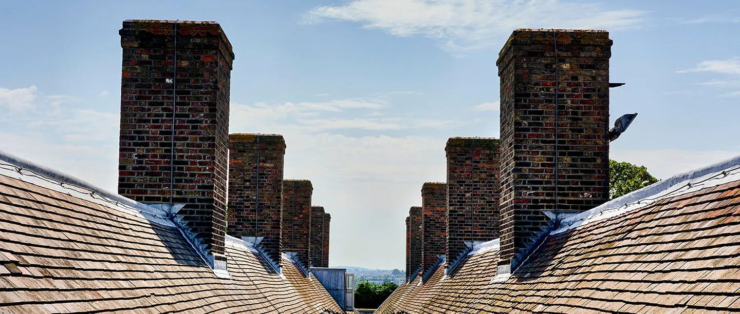 Tall brick chimney stacks along the tiled roof of the barracks