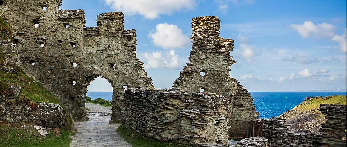 The ruined courtyard walls and arch against a blue sky