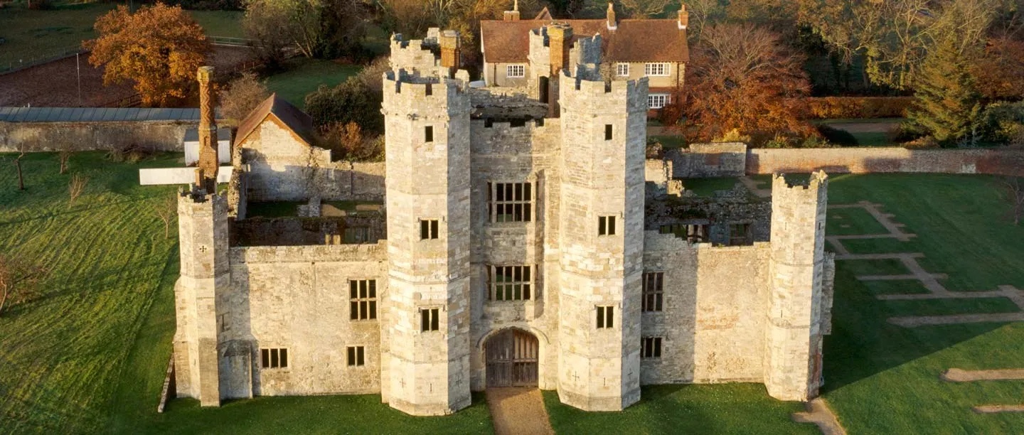 Aerial view of Titchfield Abbey's gatehouse in autumn light, with the outline of the church's walls marked in the grass