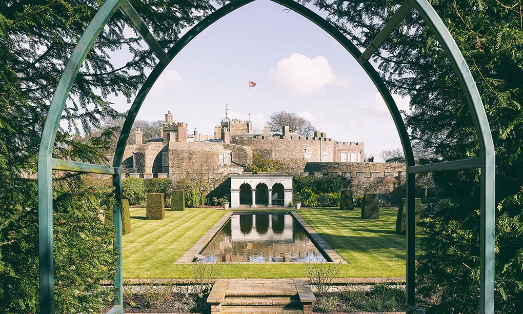The Queen Mother's Garden and its long pool framed by a green iron arch, the castle behind