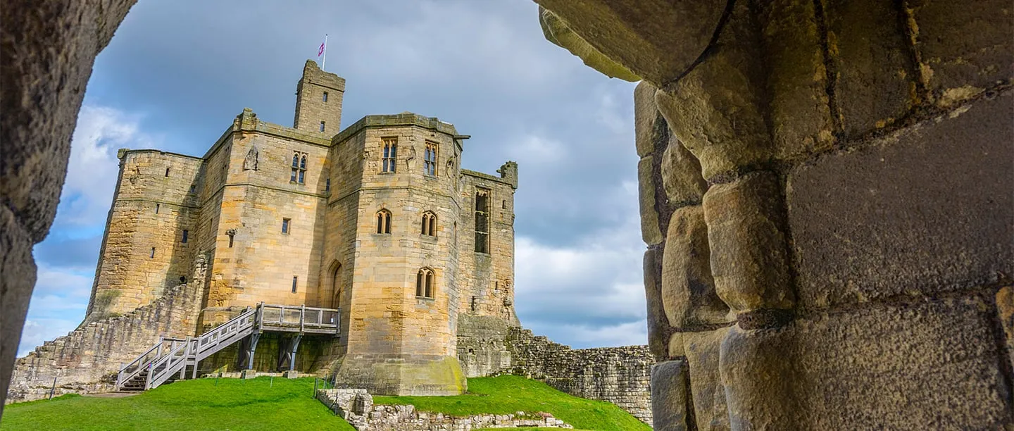 The cross-shaped great tower and its timber stair, framed by a stone archway