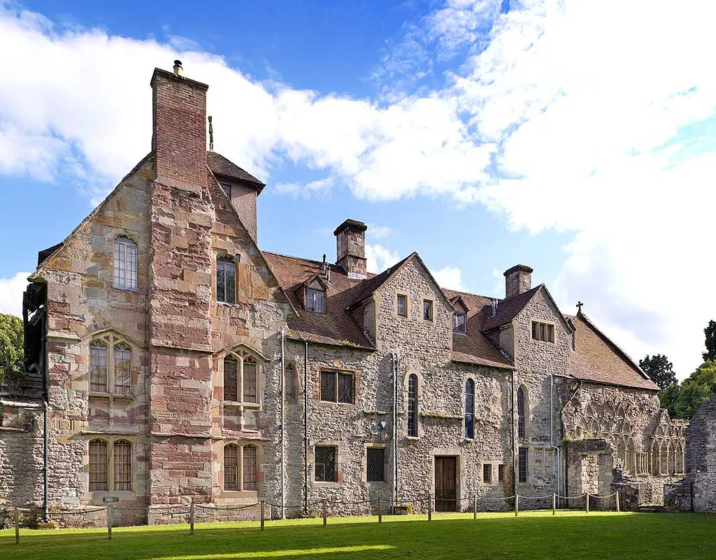 The stone gable and chimney of the infirmary hall and prior's lodging at Wenlock Priory under a blue sky