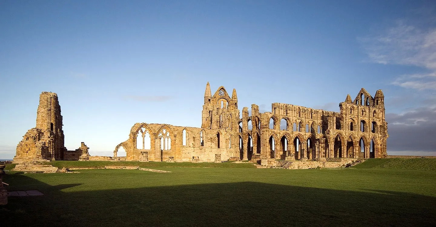 The whole length of the abbey ruins in low evening sun