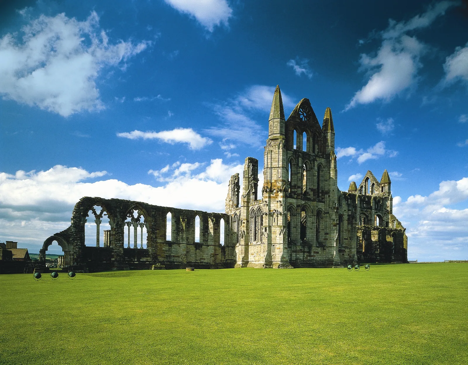The abbey ruins on the clifftop under a blue sky with white clouds